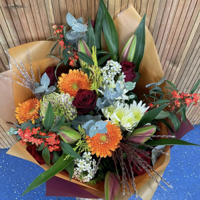 Harvest Moon - A beautiful seasonal handtied created using orange, red and white flowers with complimentary foliage. Hand delivered with care in and around Newcastle by Fantasia Florist.